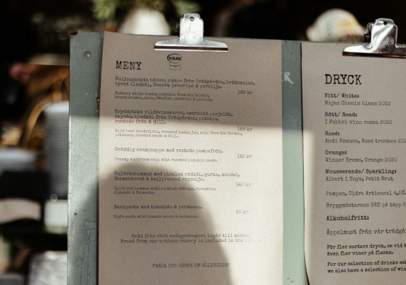 A menu sitting on top of a table next to a cup of coffee