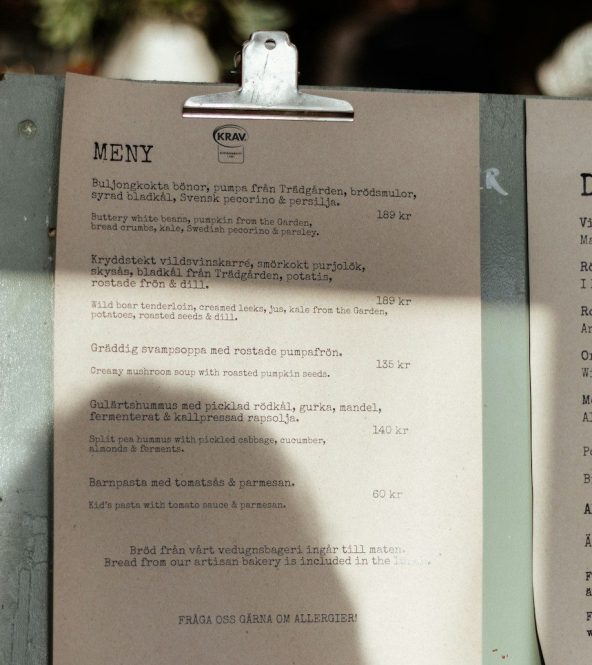 A menu sitting on top of a table next to a cup of coffee