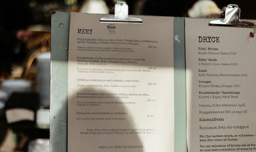 A menu sitting on top of a table next to a cup of coffee