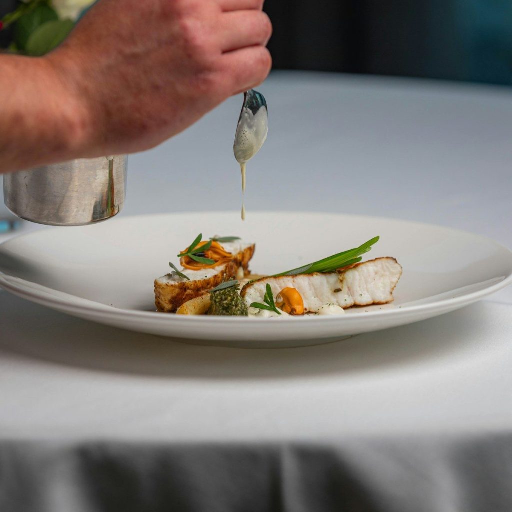 a white plate topped with fish and vegetables