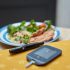 a plate of food and a Glucometer on a table